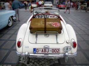 Voiture ancienne avec une valise attachée dessus