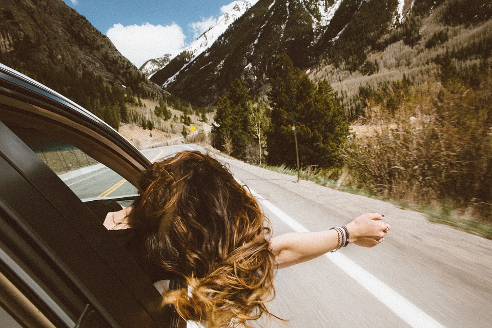 Femme passant la tête par la fenêtre d'une voiture