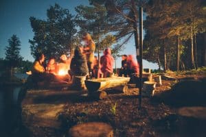 Vacanciers autour d'un feu de camp la nuit dans un camping